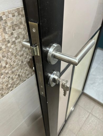 A new door handle and lock set installed on a bathroom door